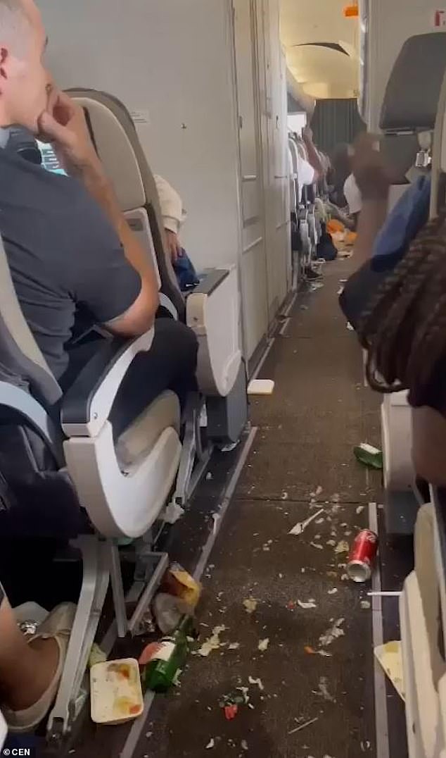 Two clips show how meals, trays, and plastic cutlery litter the aisles on the flight from Luanda to Lisbon on March 23