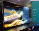 Hisense ULED X TV with NBA logos in background on aqua banner
