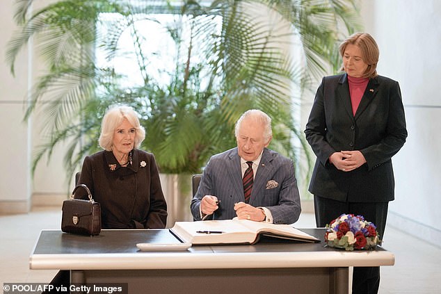 King Charles and Camilla, Queen Consort sign the guest book as Bundestag President Baerbel Bas watches on this morning
