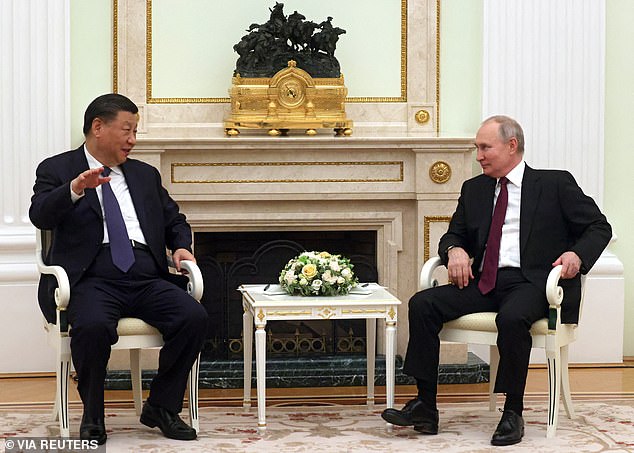 A shaky-looking Vladimir Putin praised his 'dear friend' President Xi Jinping while he gripped the arms of his chair during the Chinese leader's visit to Moscow today