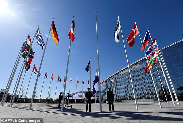 Finland has become the 31st member of NATO, in a historic strategic shift provoked by Vladimir Putin's illegal invasion of Ukraine. Pictured: Finnish military personnel install the Finnish national flag at the NATO headquarters in Brussels, on April 4, 2023