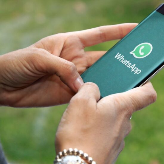 a person holding a phone with the WhatsApp logo on it