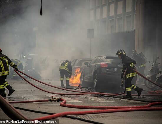 Pictured: Firefighters are seen in Milan working to extinguish cars that caught fire after a large blast rocked the city's Porta Romana neighborhood on Thursday
