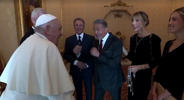 Stallone can be seen raising his fists like a prized fighter before the pope, wearing his traditional white robes and a skullcap, does his best imitation, surrounded by Stallone's family members