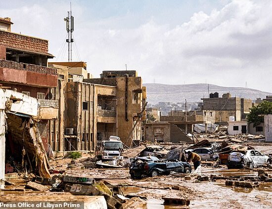 Some 10,000 people are still missing in Libya after 'catastrophic' floods obliterated entire neighbourhoods, with officials warning the death toll is 'huge' and could end up in the thousands. Pictured: Destroyed vehicles and buildings line the streets in the eastern city of Derna in Libya on Monday