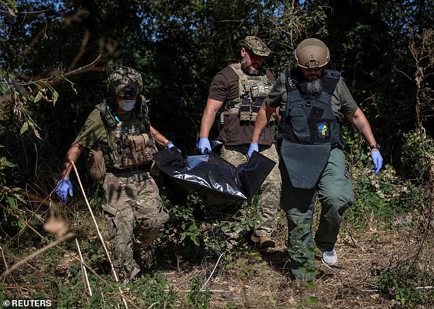Vladimir Putin 's invasion of Ukraine 'is just the beginning' and 'the war will not stop there', a Russian general recently promoted by the Kremlin has warned. Pictured: Ukrainian servicemen carry a body bag containing a dead Russian soldier, September 8, 2023