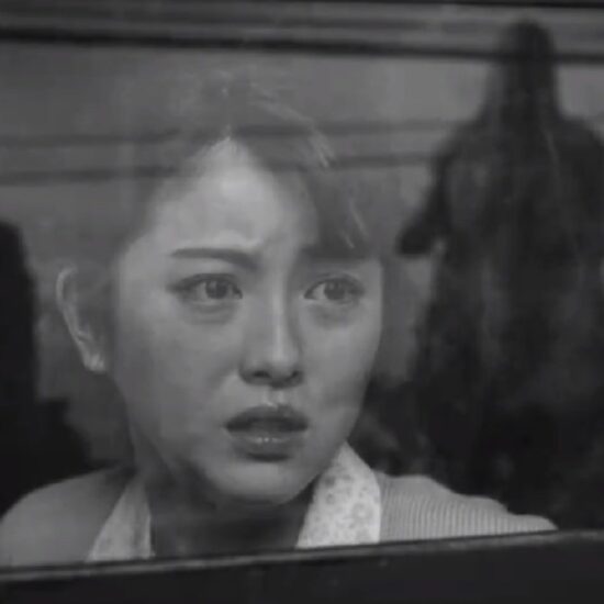 A scared woman looks out the window of a train and sees Godzilla rampaging through the city in Godzilla Minus One in black and white.