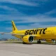 A yellow Spirit airplane on the ground at an airport