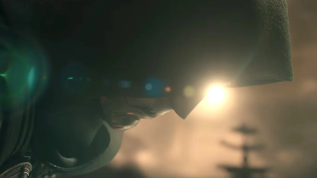 Dr Doom kneeling with his mask and hood on with a setting sun behind him in Avengers: Doomsday