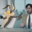 Wile E. Coyote with his arms stretched out as Will Forte looks nervous in Coyote vs. ACME