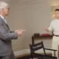 White-haired historian Tom Holland and the actor Tom Holland do the Spider-Man pointing meme between a chair with their shared name on it