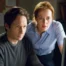 Mulder (David Duchovny) and Scully (Gillian Anderson) look at a computer screen.