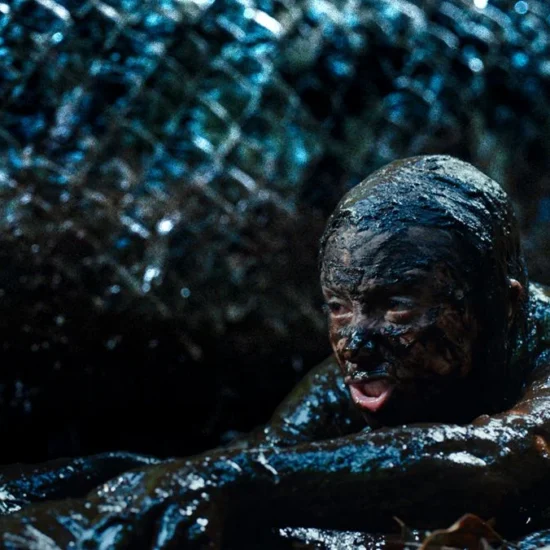 A still from Beware Boi&uacute;na, showing a terrified doctor covered in mud with the enormous snake behind her.