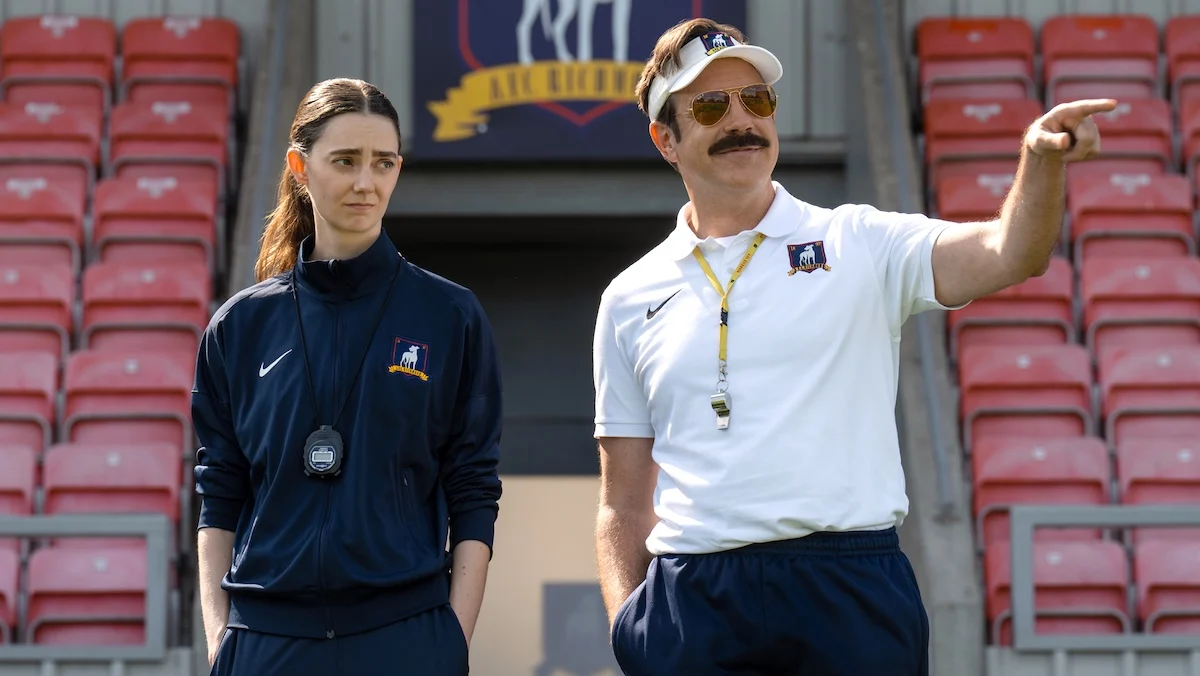 Ted Lasso and Rebecca meet on the tarmac in front of a plane