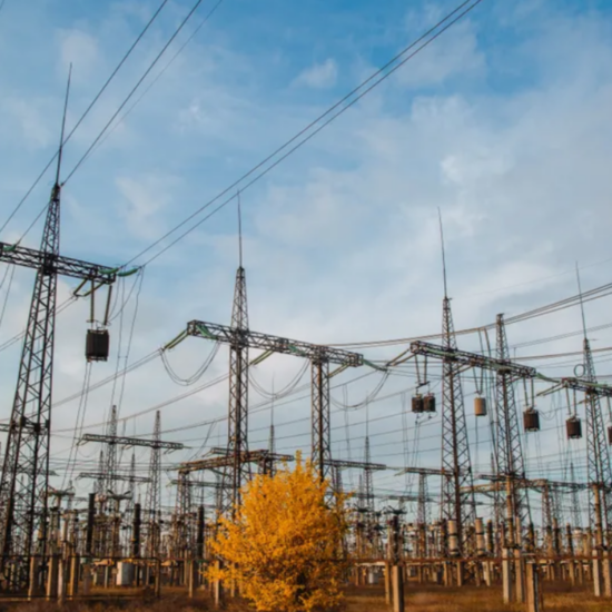 Electrical pylons and high voltage power lines are behind a barbed wire fence. critical infrastructure