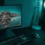 A high-end gaming PC setup with a monitor, mechanical keyboard, mouse, and a glowing desktop tower in teal lighting.