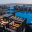 Voxel Minecraft-style city with detailed buildings, water, and warm interiors from a decade-long architecture project