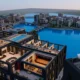 Voxel Minecraft-style city with detailed buildings, water, and warm interiors from a decade-long architecture project