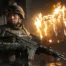 A soldier in tactical gear holding a rifle in front of a burning building in Call of Duty: Modern Warfare 4.