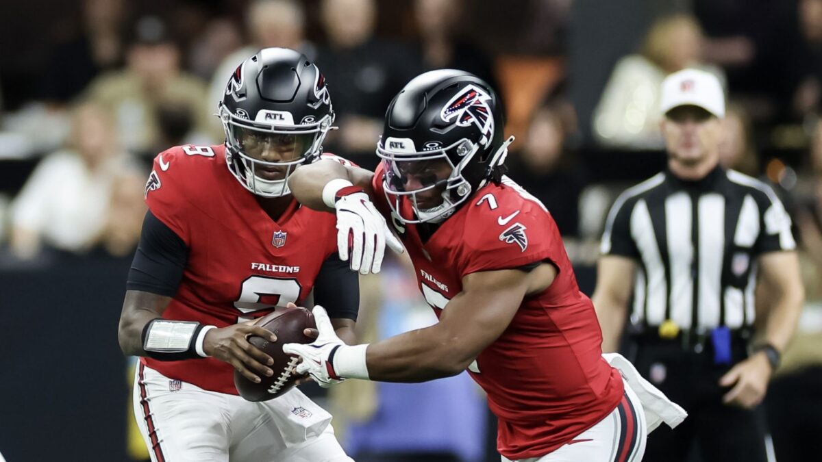 Atlanta Falcons quarterback Michael Penix faking a handoff to running back Bijan Robinson