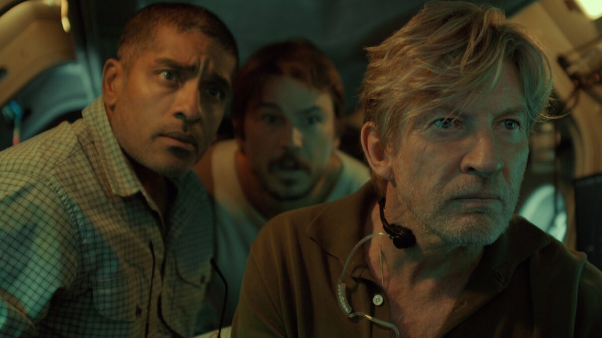 &Quot;Three Men In A Dimly Lit Submarine Interior Look Intently At A Screen, Surrounded By Equipment And Controls, Suggesting A Tense Or Serious Moment In An Underwater Or Scientific Environment.&Quot;