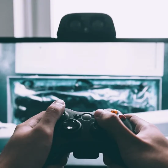 A person holding a video game controller in front of a television screen